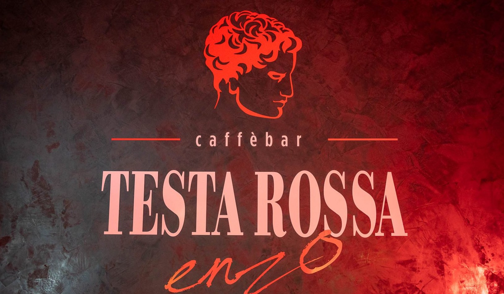 cafébar TESTA ROSSA enzo Schwaz Logo an der Wand